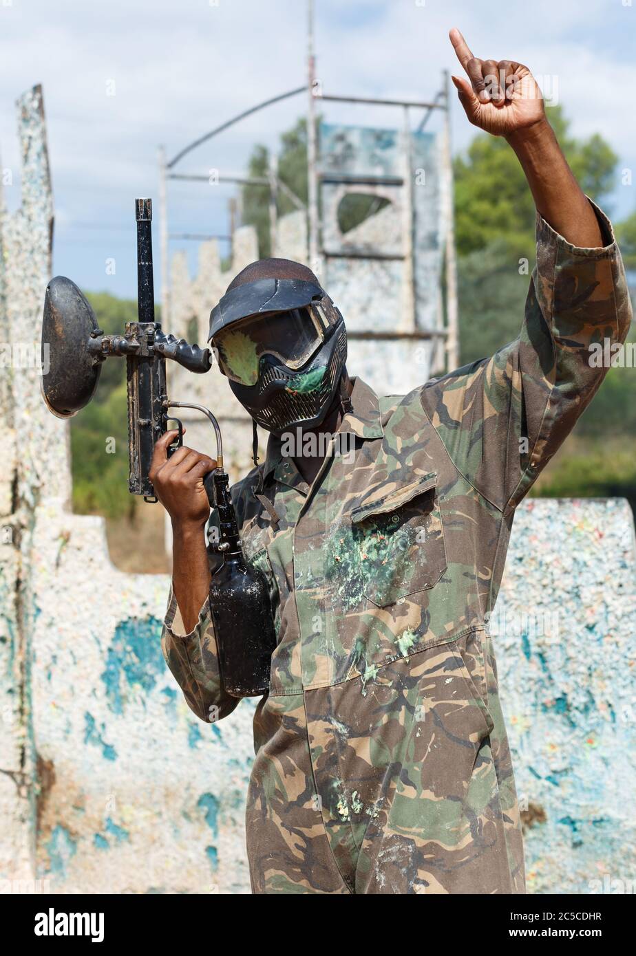 Portrait d'un homme afro-américain sous forme protectrice et masque avec éclaboussures de peinture après avoir joué au paintball à l'extérieur Banque D'Images