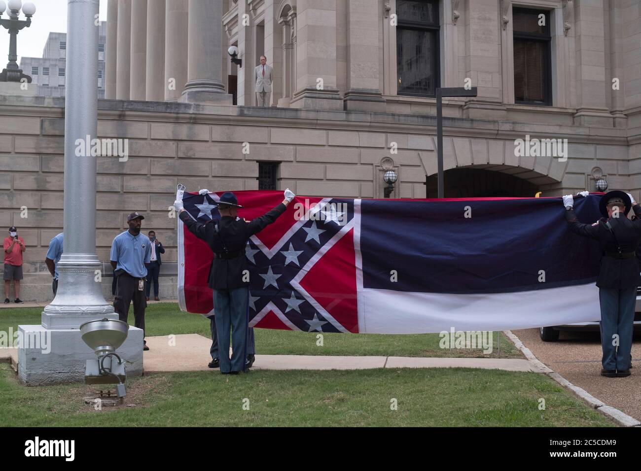 (200702) -- MISSISSIPPI, 2 juillet 2020 (Xinhua) -- le drapeau de l'État du Mississippi est abaissé du Capitole lors d'une cérémonie à Jackson, Mississippi, États-Unis, le 1er juillet 2020. Tate Reeves, gouverneur du Mississippi, État du sud des États-Unis, a signé mardi une loi d'État, supprimant officiellement du drapeau de l'État un emblème de bataille confédéré, a rapporté les médias locaux. Dimanche, les législateurs du Mississippi ont massivement voté pour remplacer le drapeau de l'État, alors que les manifestants de tout le pays ont exigé de rendre compte du racisme systémique après la mort de l'homme noir George Floyd Banque D'Images