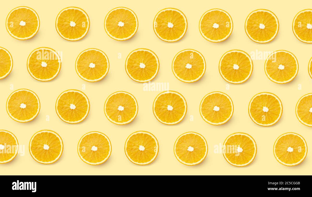 Motif transparent avec tranches orange sur fond jaune. Vue de dessus, plat citronné Banque D'Images