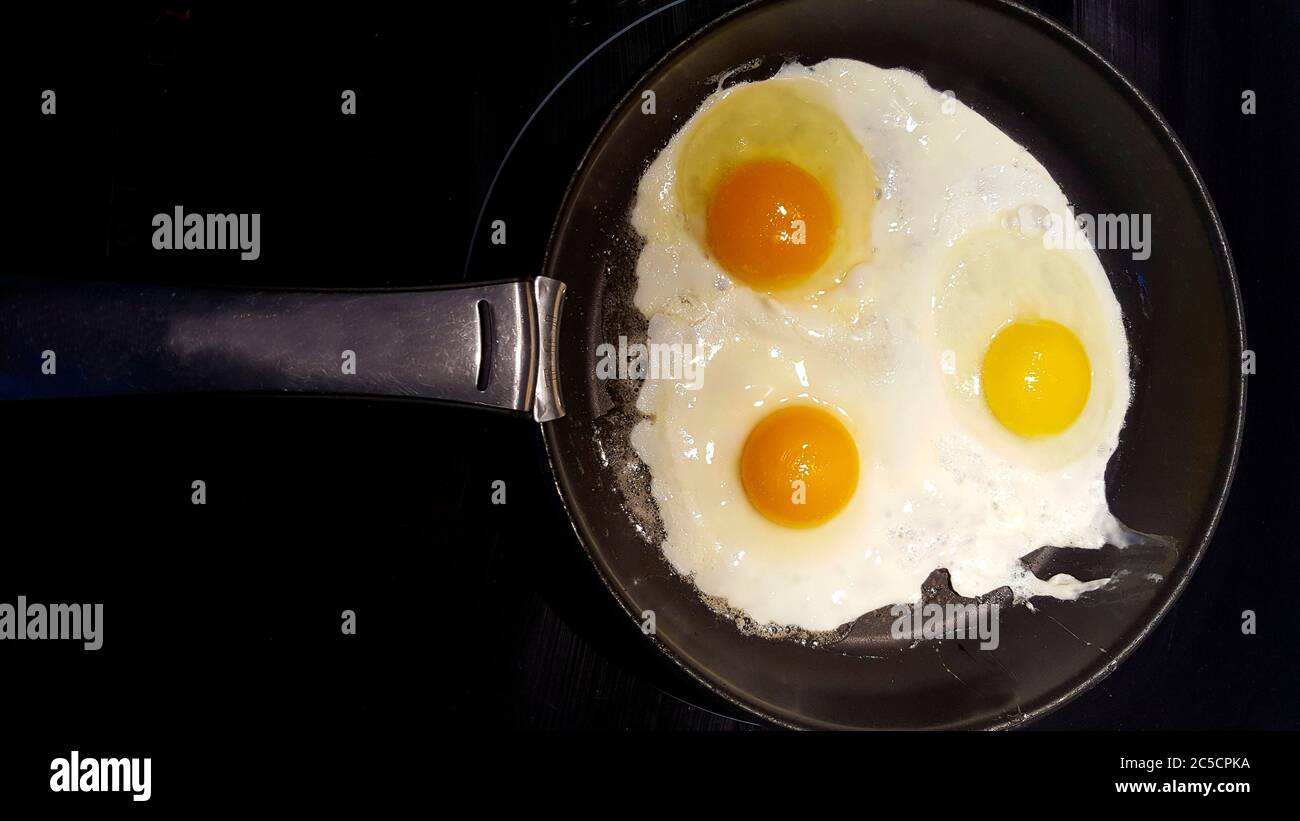 Vue de dessus des œufs frits cuits dans une poêle Banque D'Images