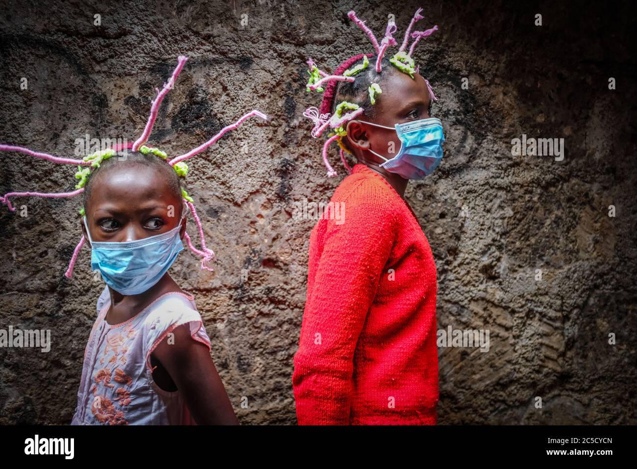 Martha APISA et Stacy Ayuma utilisent leurs tresses de style capillaire pour créer la conscience et la sensation sur le coronavirus (COVID-19).les petites filles du Kenya utilisent leurs coiffures pour transmettre la conscience et la sensation aux gens de Kibera de prendre des mesures de sécurité pour éviter la propagation du virus Corona. Ces petites filles, Stacy Ayuma, 12 ans, et son amie Martha APISA, 13 ans, décorent leurs cheveux à chaque fois pour s'assurer que les gens autour d'eux savent qu'il y a un ennemi mortel en supposant le monde entier et n'épargne personne. Banque D'Images