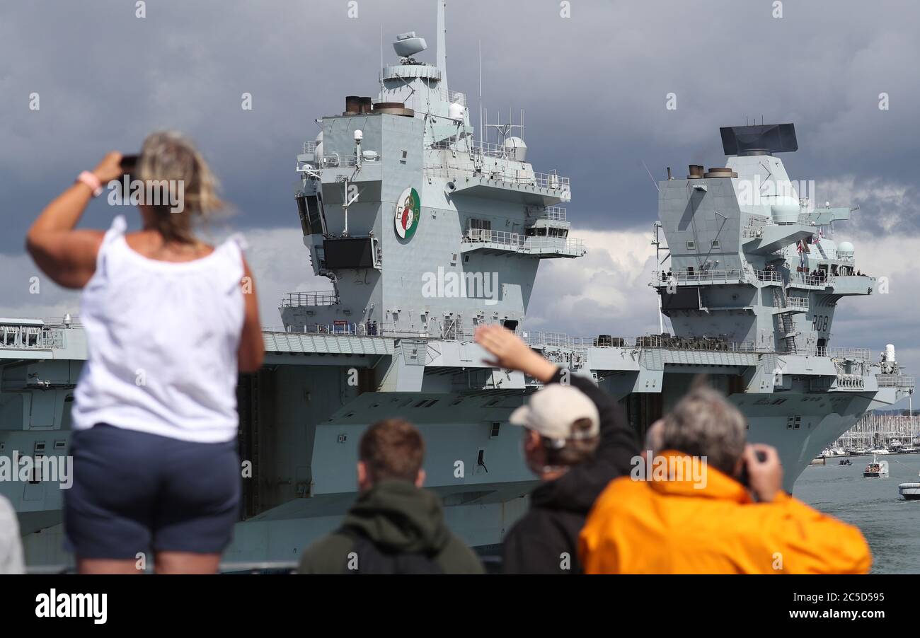 Les gens se déferent de la tour ronde alors que le HMS Queen Elizabeth revient à la base navale de Portsmouth après avoir effectué des essais en mer et en vol avec des jets F35B Lightning pour le préparer à la préparation du Carrier Strike Group avant son premier déploiement opérationnel l'année prochaine. Banque D'Images