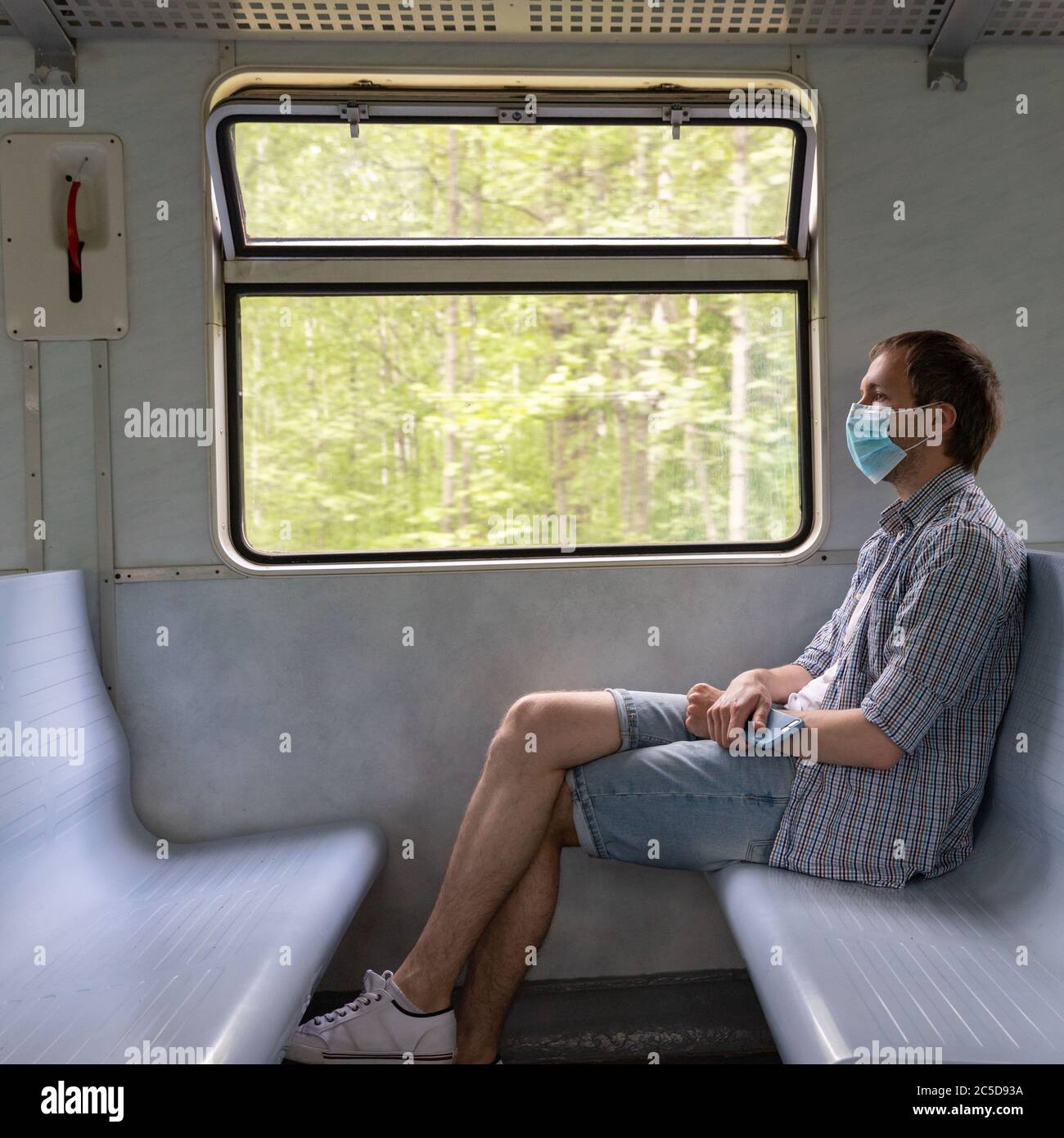 L'homme triste porte un masque protecteur dans le train pour protéger le système respiratoire contre l'infection à coronavirus, Covid-19. Mesure préventive. Nouvelle normale. Banque D'Images