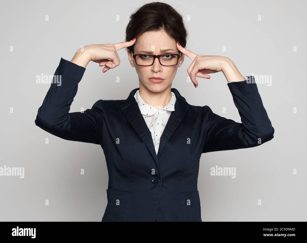 Femme d'affaires, difficile à penser. Isolé sur gris Banque D'Images