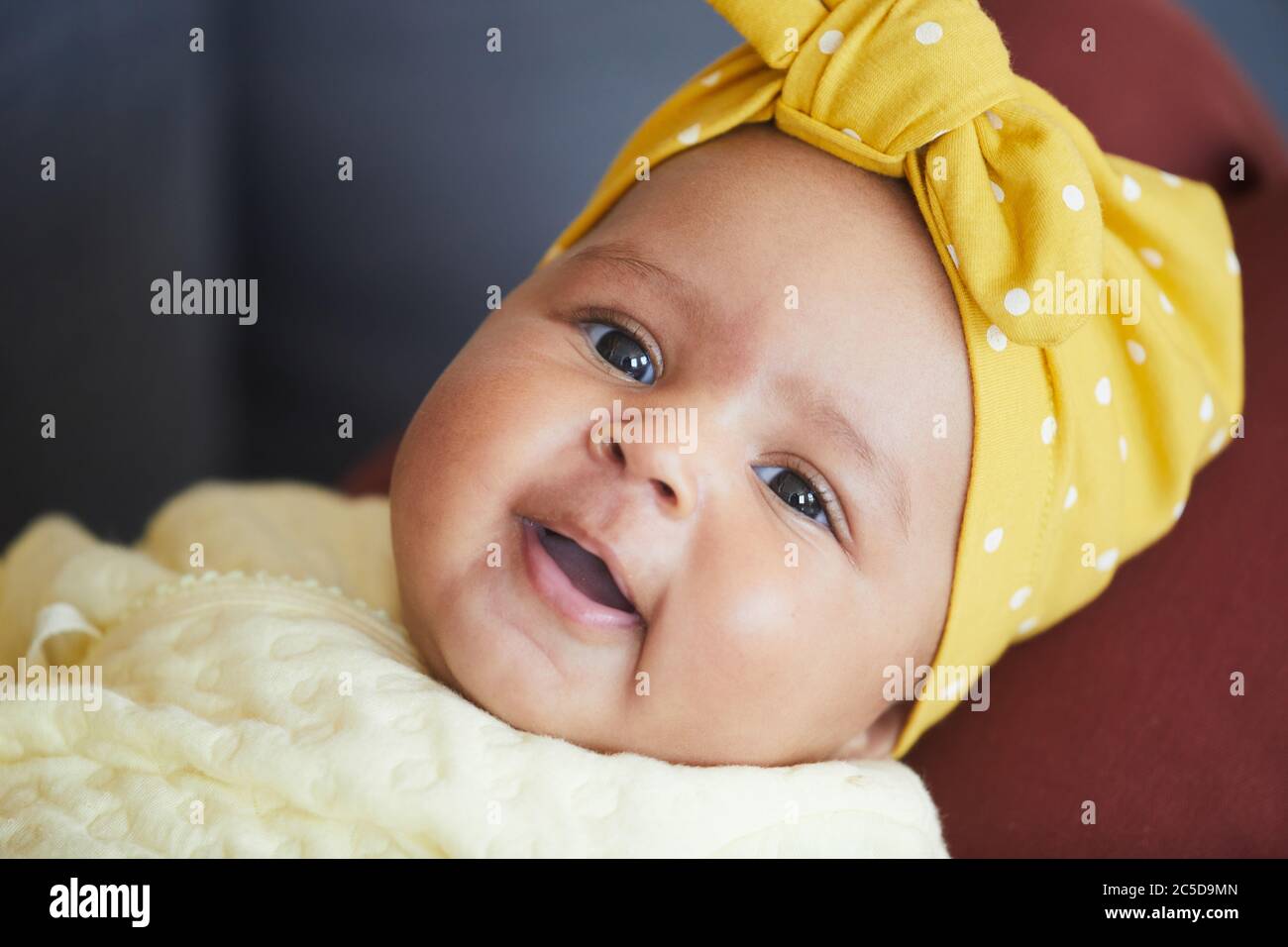 Portrait de petite fille mignonne avec un noeud sur la tête regardant l'appareil photo Banque D'Images