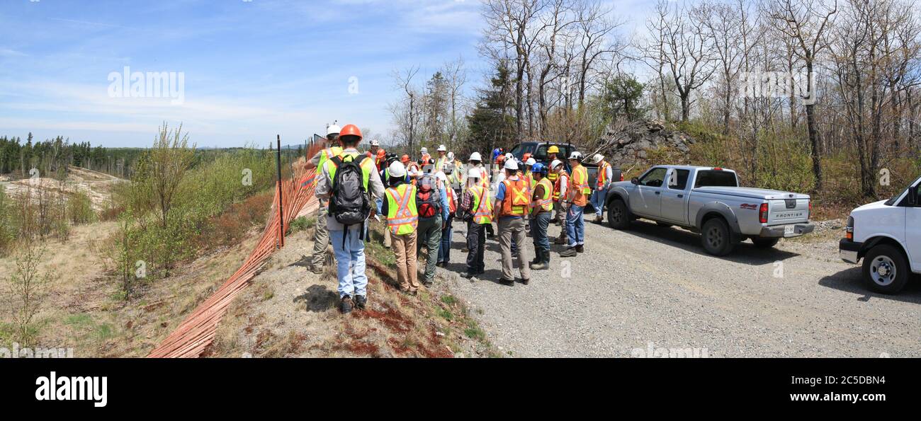 SUDBURY, ONTARIO, CANADA - MAI 21 2009 : groupe de travailleurs et de géologues en casques de sécurité et gilets de haute visibilité sur la route. Banque D'Images