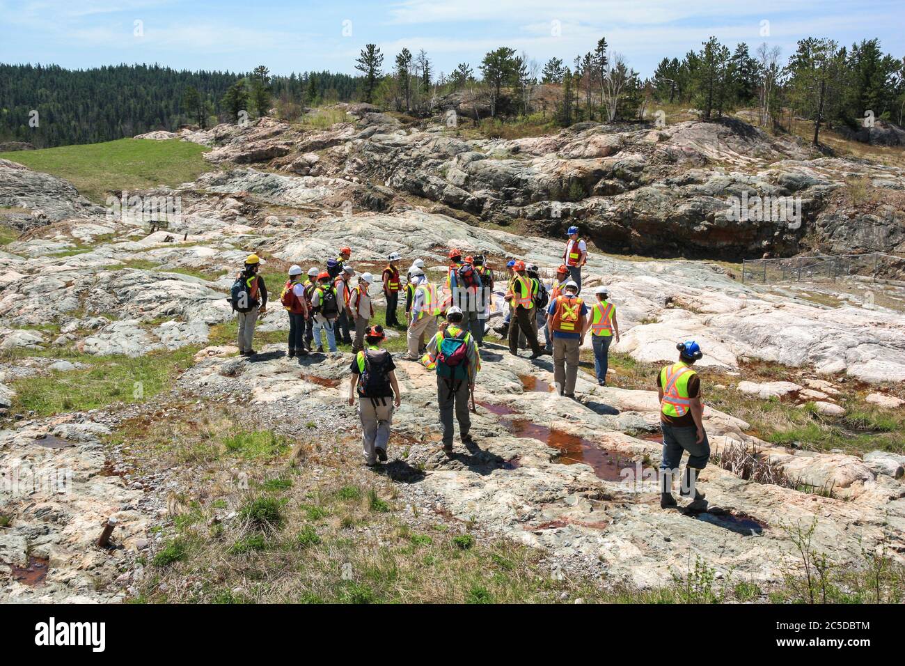 SUDBURY, ONTARIO, CANADA - MAI 21 2009 : groupe de travailleurs et de géologues en casques et gilets haute visibilité sur un site géologique hors-récolte. Banque D'Images