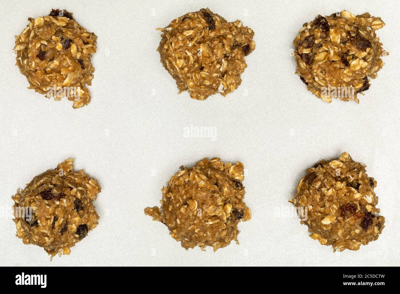 Flocons d'avoine, biscuits au raisin, boules de pâte sur plaque à pâtisserie Banque D'Images