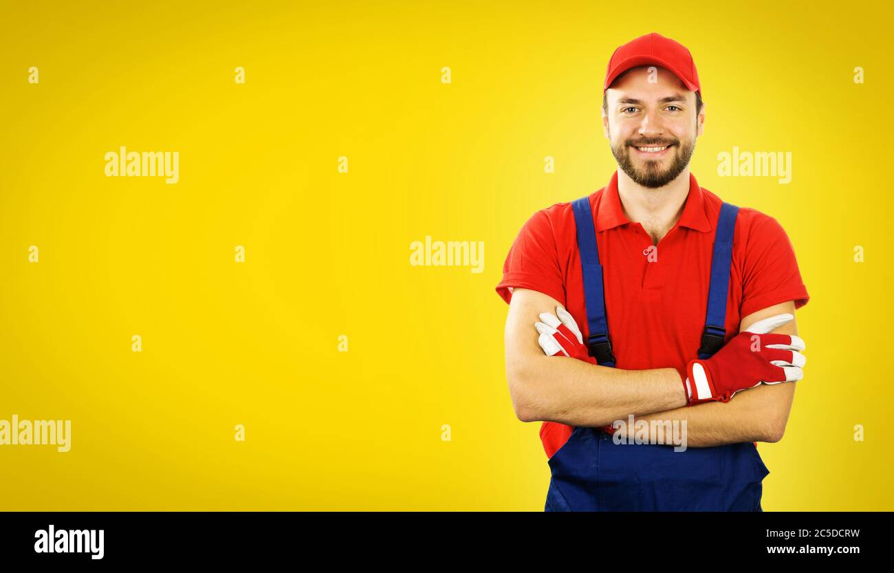 homme de main souriant avec bras croisés sur fond jaune avec espace de copie Banque D'Images