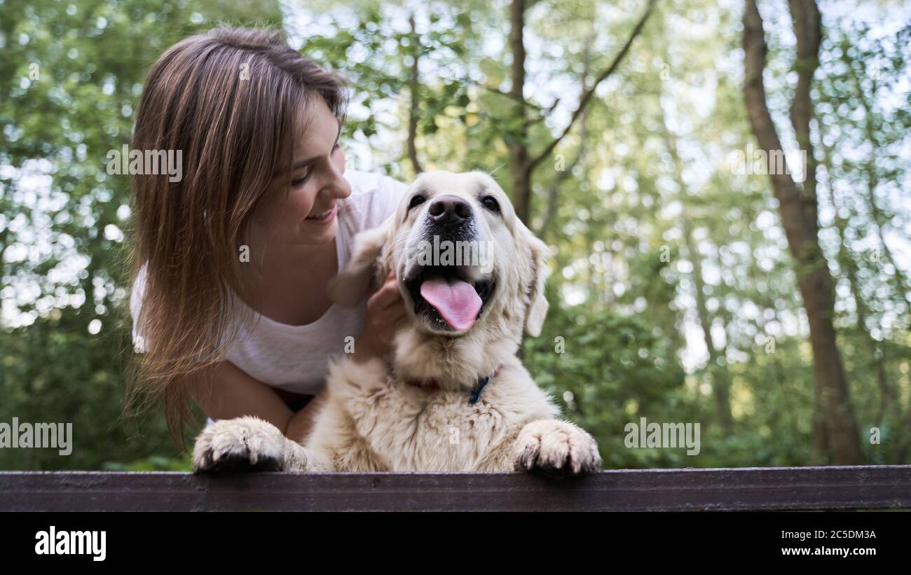 Bonne femme avec un chien debout sur le pont au milieu de la forêt jour d'été Banque D'Images