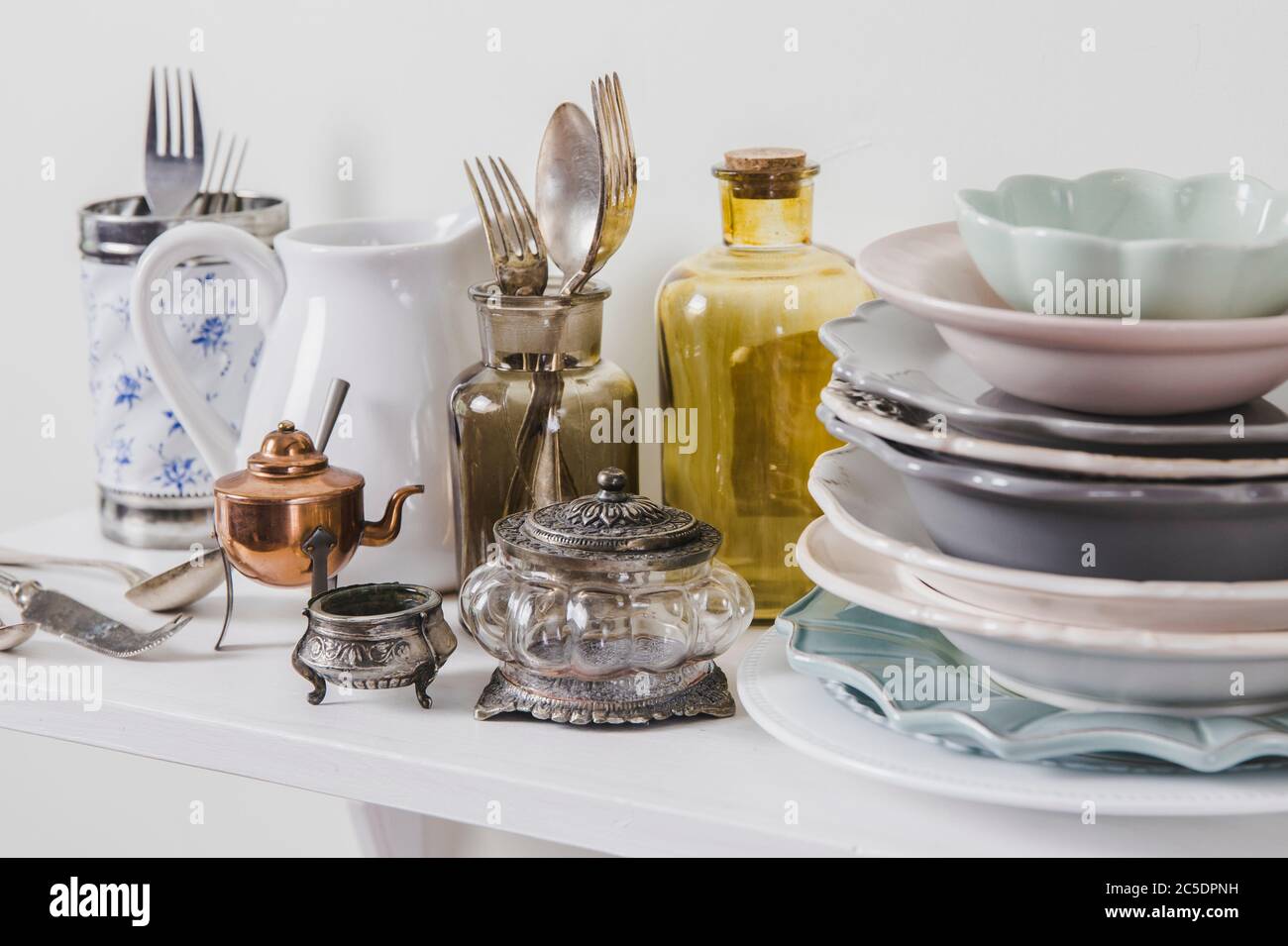 Acheter de la vaisselle ancienne vintage romantique dans le concept de magasin secondaire. Pile de vaisselle ancienne sur l'étagère du magasin pour la cuisine. Banque D'Images