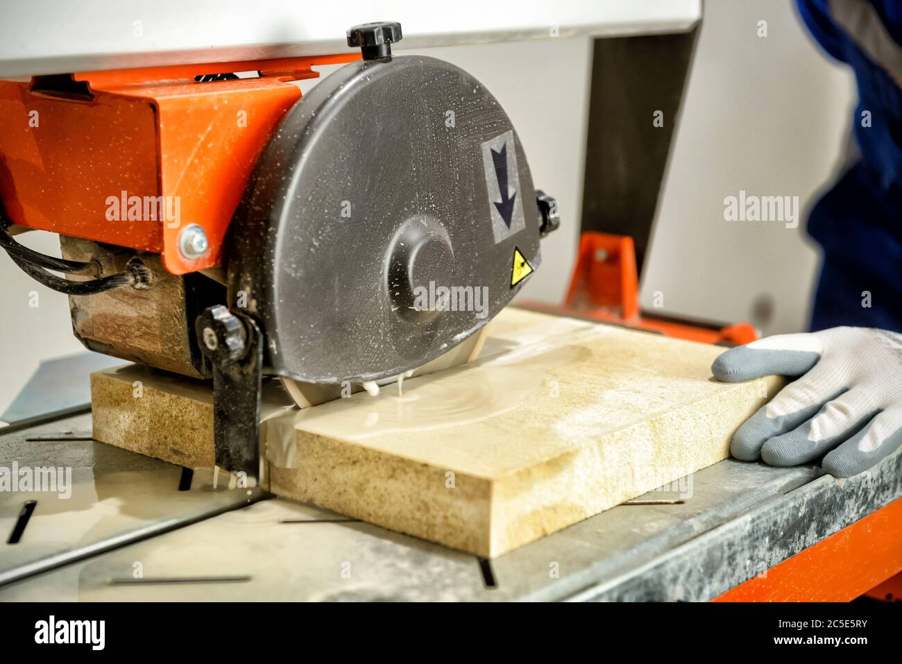 L'employé coupe les carreaux à l'aide d'une scie circulaire Banque D'Images