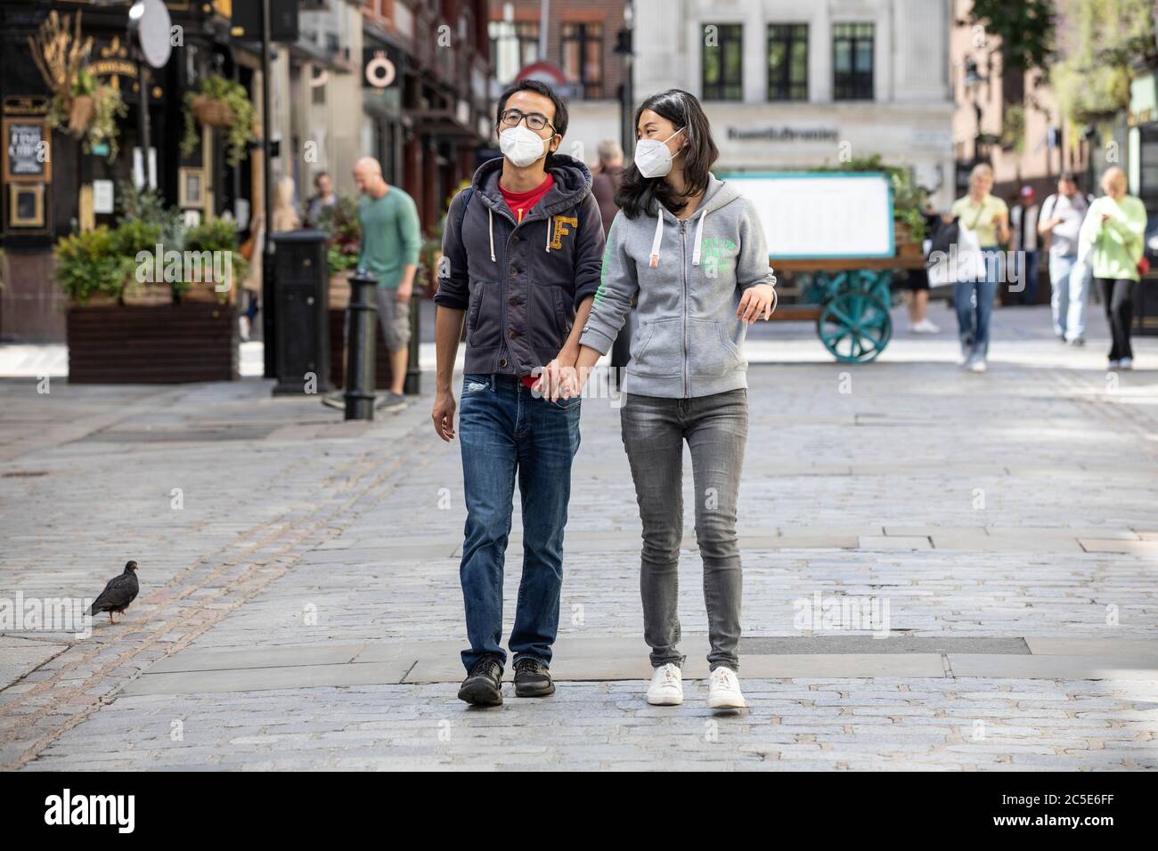 Covent Garden, Londres, Royaume-Uni/ 2 juillet 2020. Un couple portant des masques de visage se promondent le long de la piazza dans le jardin de Covent avant le Super samedi, avant que les restrictions de verrouillage du coronavirus soient relaxantes et que des restaurants et des bars ouvrent ce week-end à travers Londres, Royaume-Uni crédit: Clickpics/Alay Live News Banque D'Images