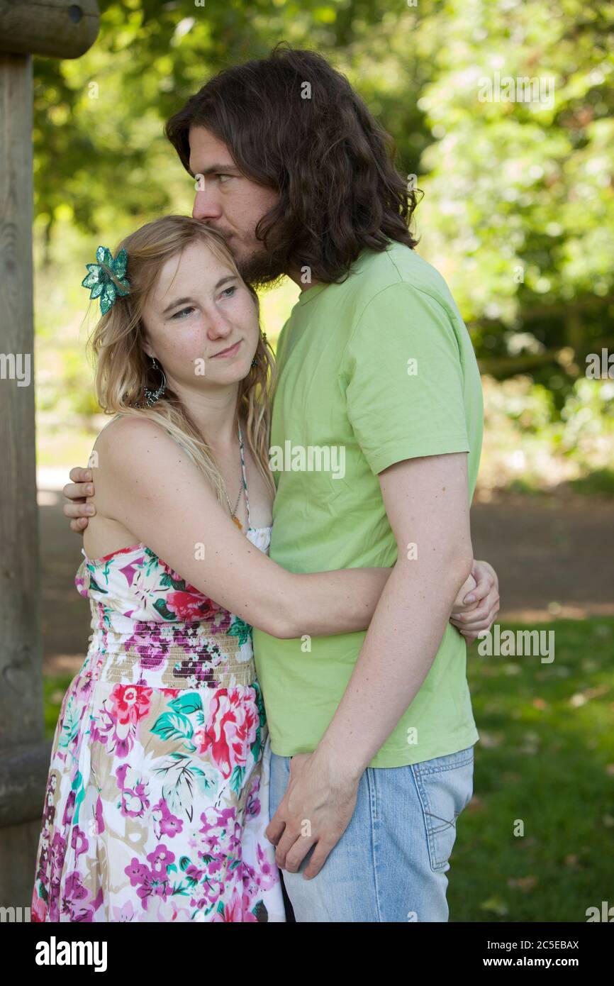 Embrassant jeune couple dans le parc lors d'une journée ensoleillée d'été, Springfield Park, Londres, modèle disponible Banque D'Images