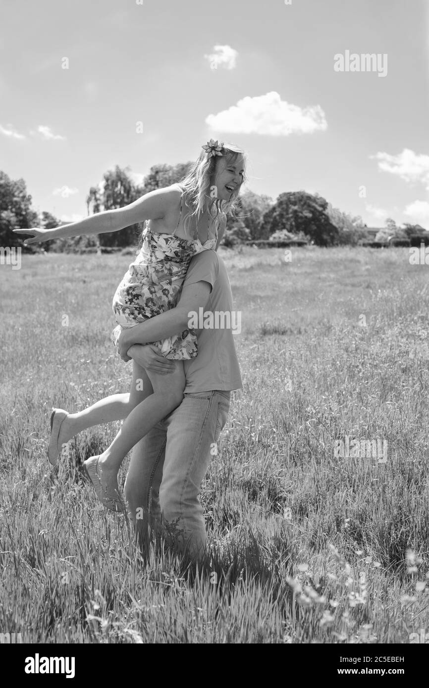Photo noir et blanc de jeune couple heureux dans le parc un jour ensoleillé d'été, qualité vintage, Springfield Park, Londres, modèle disponible. Banque D'Images