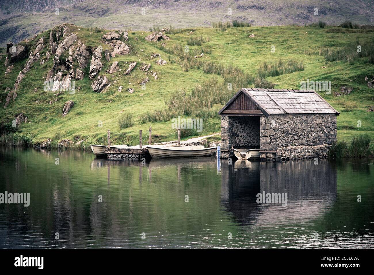 Une ancienne promenade en pierre sur un lac à Snowdonia, au nord du pays de Galles. Effet nostalgique avec vignetage intentionnel. Banque D'Images