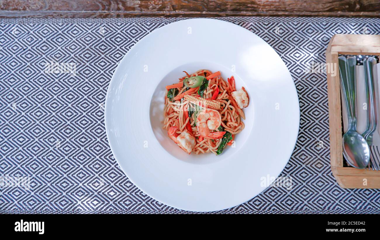 Vue du dessus image les crevettes épicées spaghetti dans une assiette blanche sur la nappe. Banque D'Images