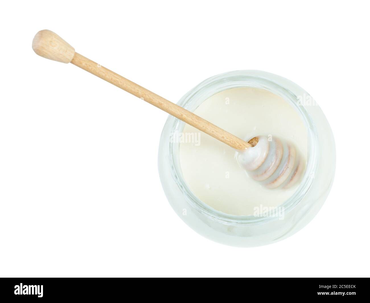 vue de dessus de bâton de bois sur la surface de miel blanc naturel organique dans un pot en verre isolé sur fond blanc Banque D'Images