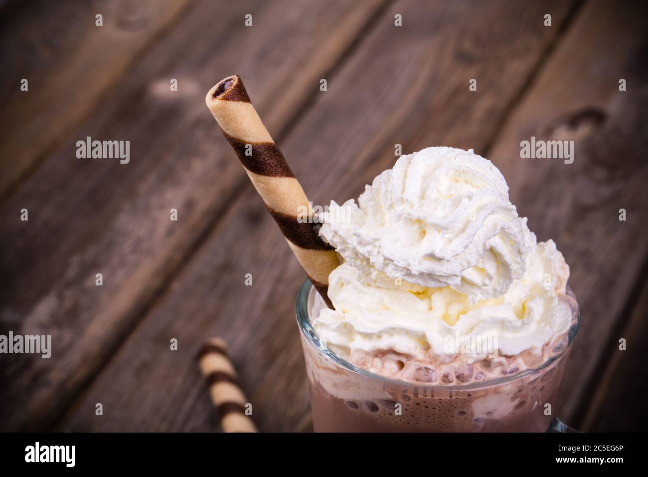 Chocolat chaud avec garniture à la crème fouettée, en verre avec galette roulée. Traitement des effets vintage Banque D'Images