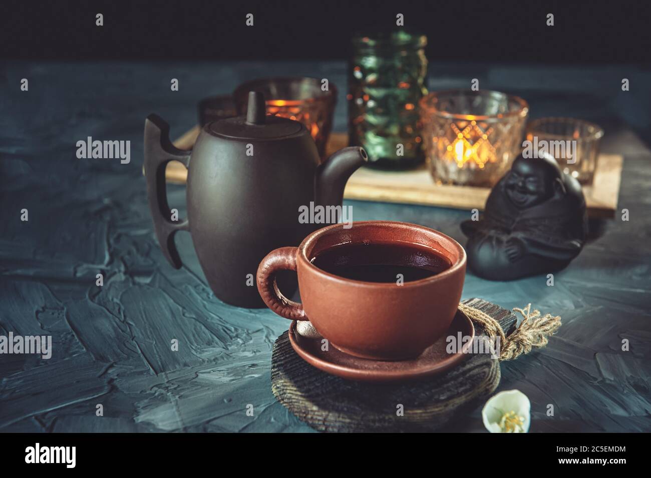 Cérémonie du thé chinois. Thé chaud dans une tasse en céramique sur le fond de chandeliers avec bougies. Mise au point sélective. Banque D'Images