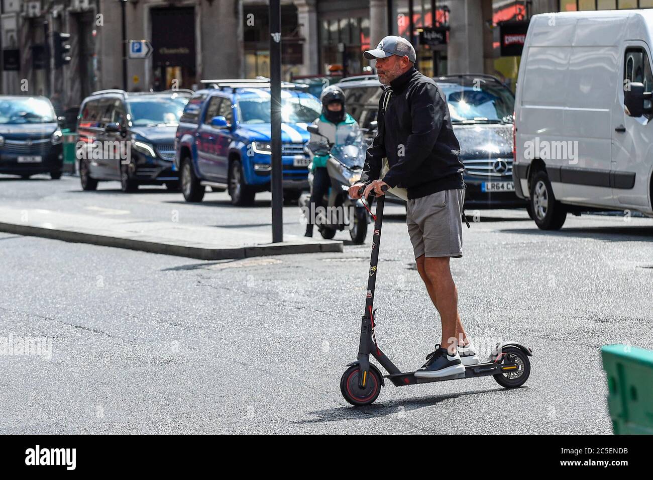 Londres, Royaume-Uni. 2 juillet 2020. Un homme fait un scooter électrique  personnel (e-scooter) dans Regent Street. Le ministère des Transports  permettra à la location de scooters électroniques de devenir légale sur les