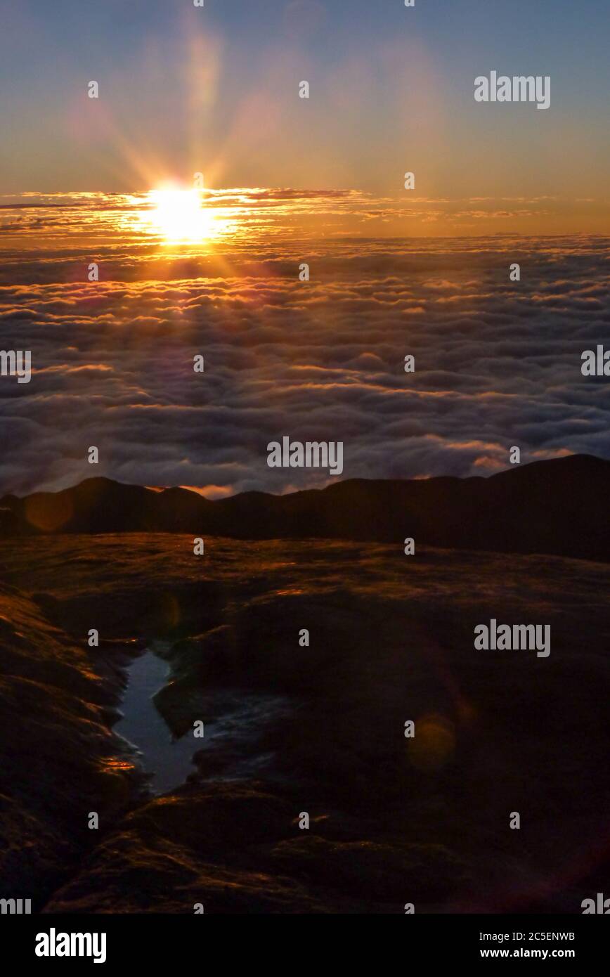 Lever de soleil au-dessus d'un tapis de nuages, vu du sommet du sommet du drapeau, dans le parc national de Caparaó, une division des États de Minas Gerais et Banque D'Images