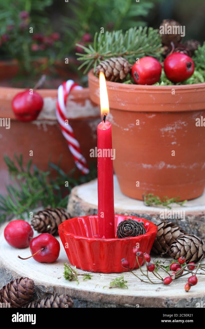 décoration de noël avec bougie rouge et pommes de crabe dans des pots en terre cuite Banque D'Images