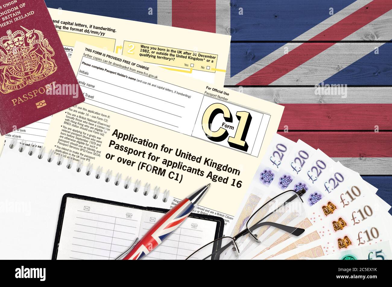 Formulaire C1 Français demande de passeport britannique pour les demandeurs  âgés de 16 ans ou plus se trouve sur une table avec des articles de bureau.  Procédure de documentation des passeports au