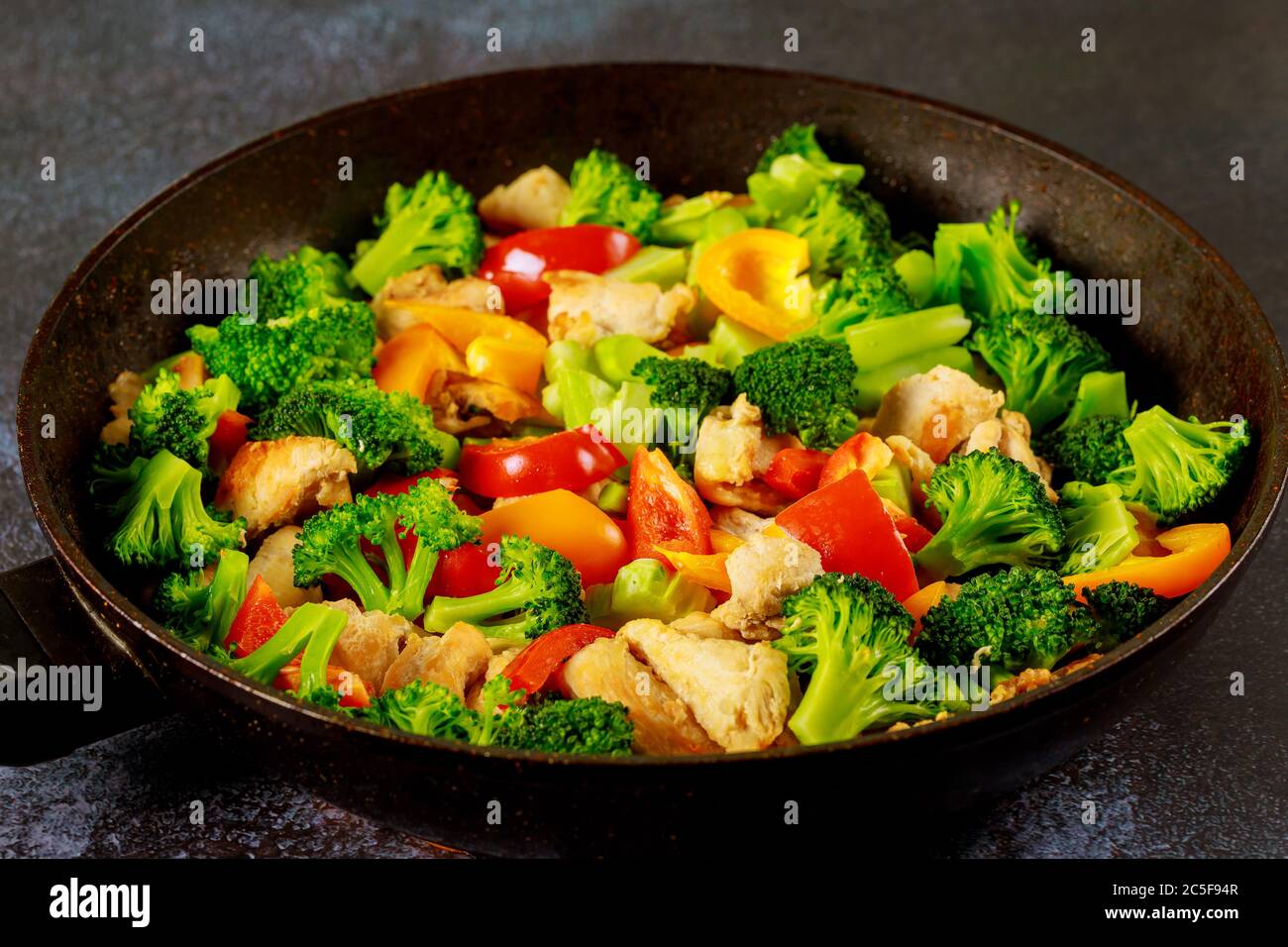 Poulet asiatique avec paprika et brocoli au wok sur fond sombre Photo Stock  - Alamy