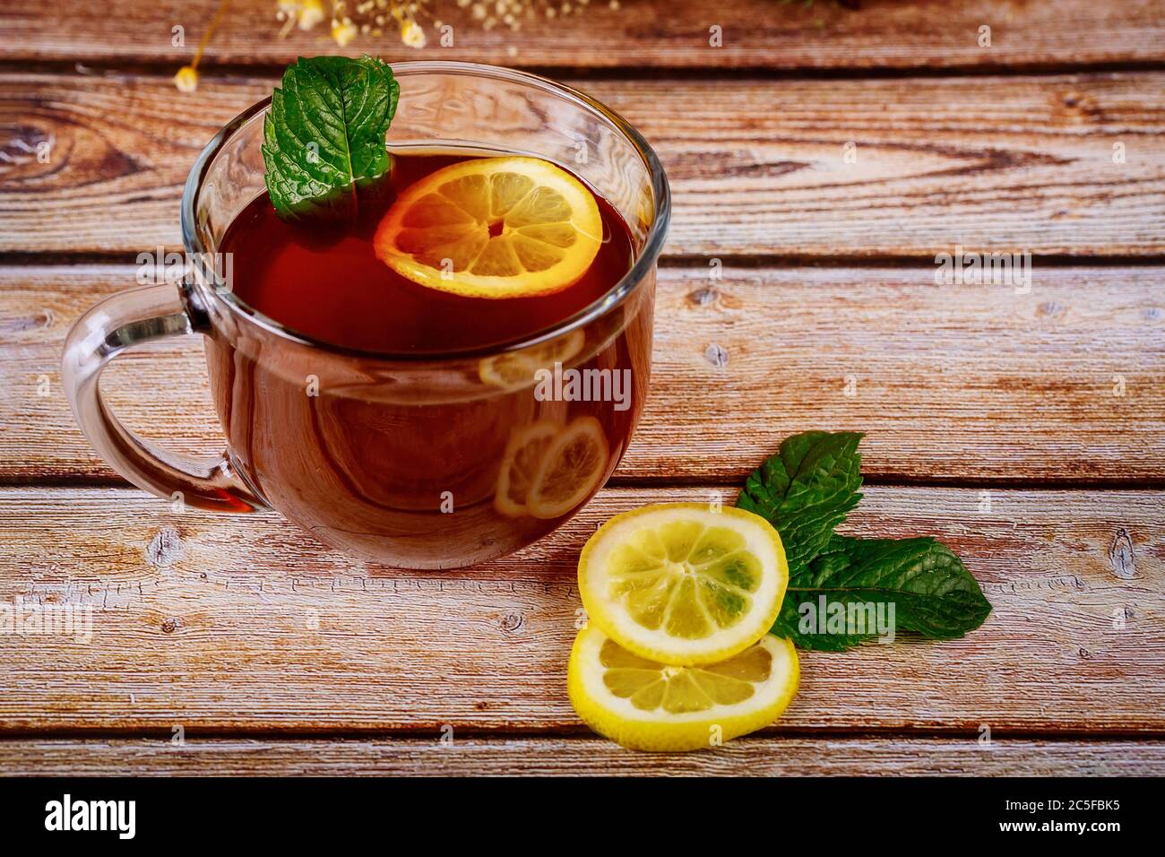Tasse de thé noir préparé avec menthe et citron sur table en bois. Banque D'Images