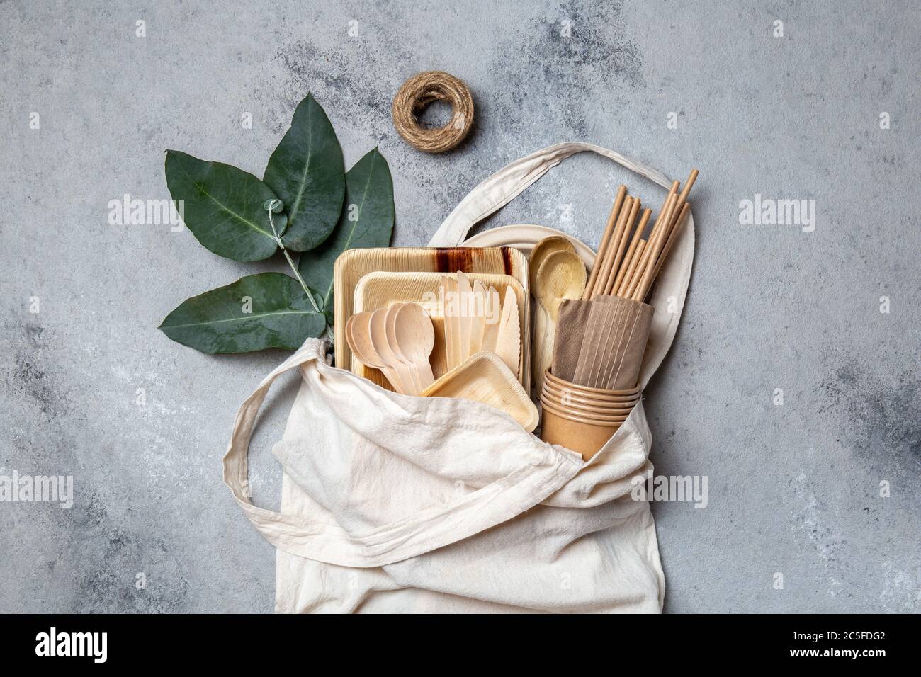 Vaisselle en papier et bois éco-artisanale. Gobelets en papier, vaisselle, sac, assiettes et couverts en bois dans un sac en lin. Recyclage ou concept écologique Banque D'Images