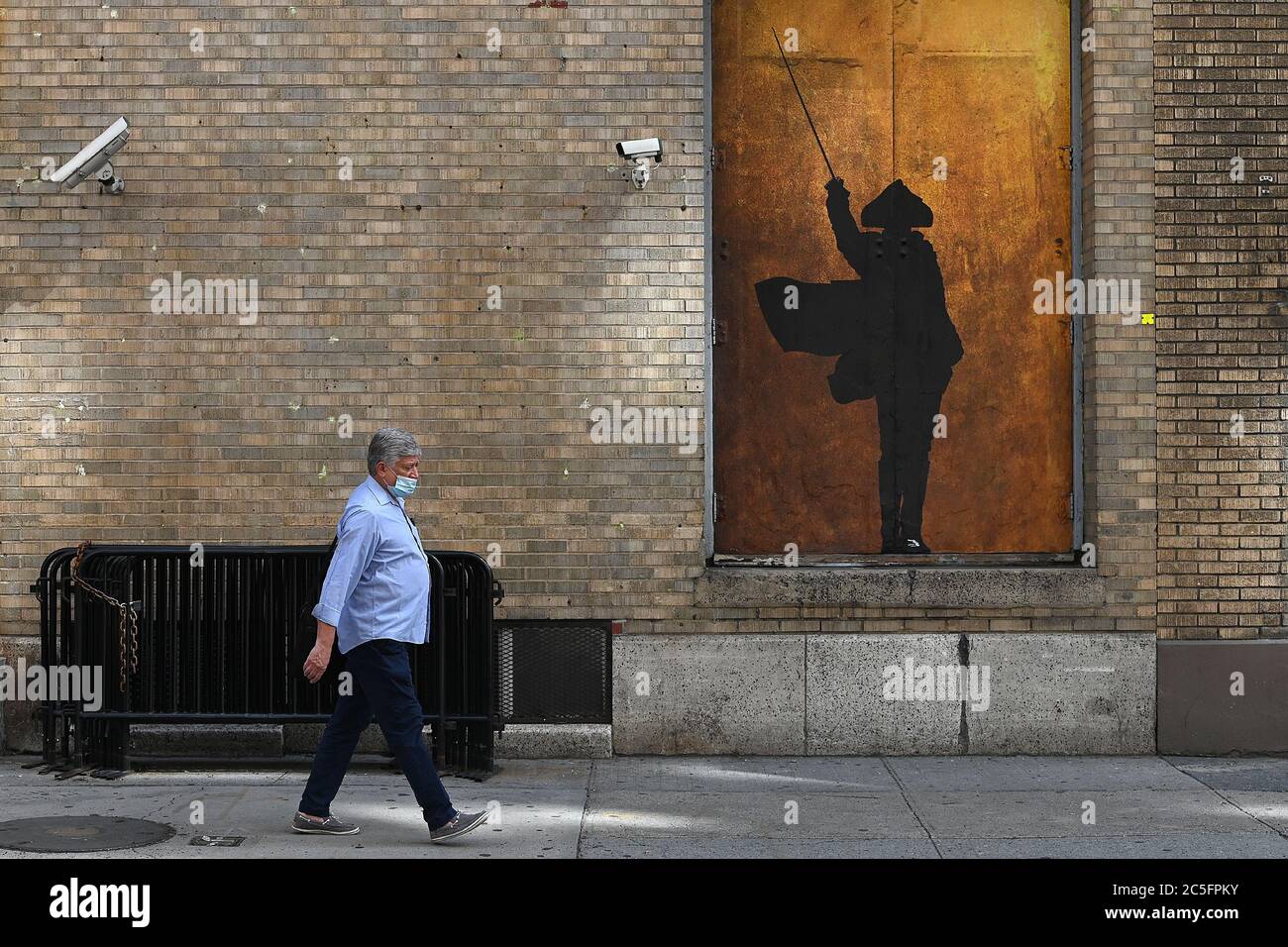 New York, États-Unis. 30 juin 2020. Un homme passe devant une porte de scène décorée d'une silhouette épées depuis la pièce de Broadway Hamilton au théâtre de la navette Richard Rodgers, car la production doit rester fermée jusqu'à la fin de 2020 en raison de la pandémie de COVID-19, New York, NY, le 30 juin 2020. Annoncé par la Broadway League, les spectacles et les spectacles de Broadway ont été fermés jusqu'à la fin de 2020, en raison de la pandémie mondiale de COVID-19. (Anthony Behar/Sipa USA) crédit: SIPA USA/Alay Live News Banque D'Images