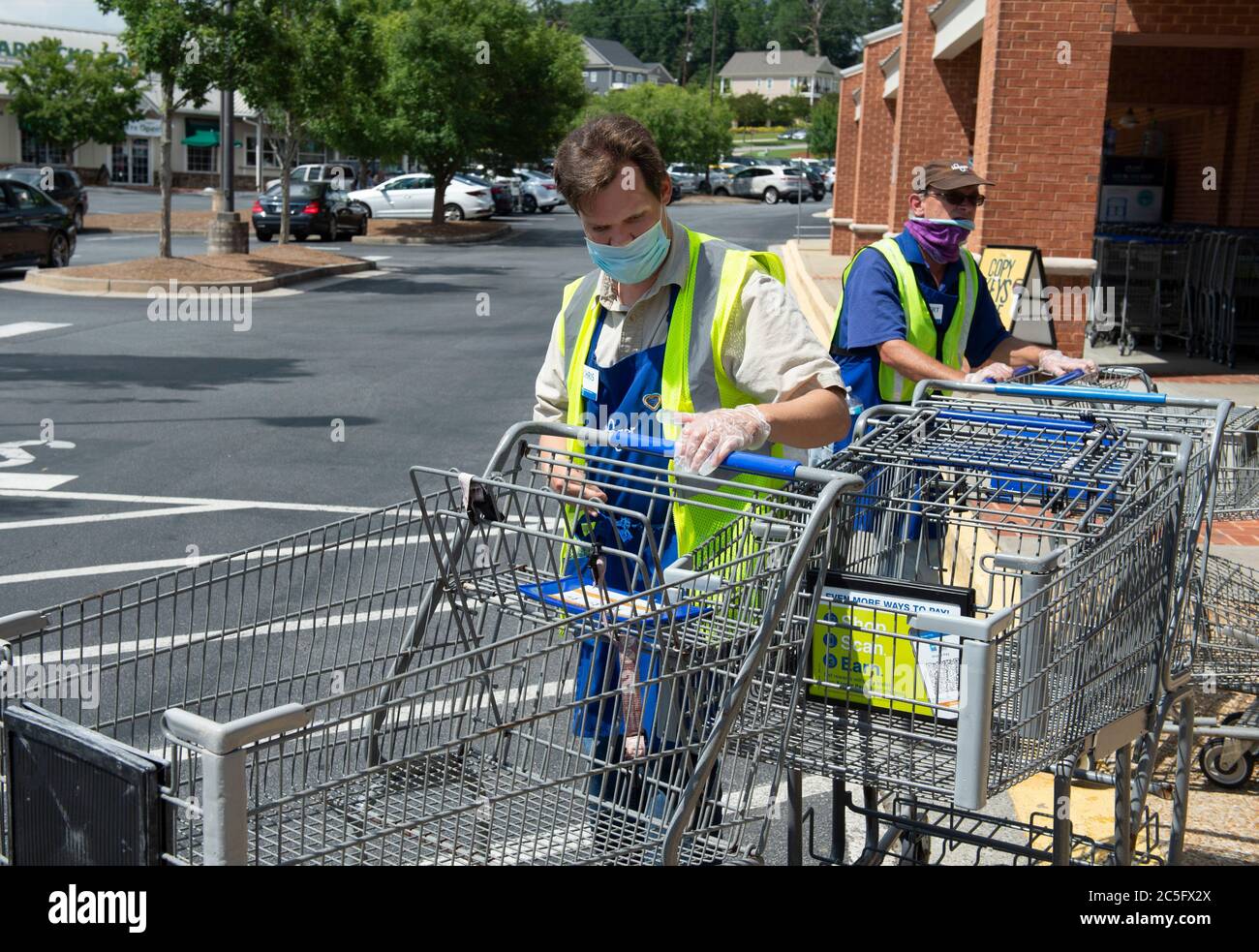 Le 2 juillet 2020, Roswell, GA : Chris Nelson, 36 ans, qui a une déficience intellectuelle, recueille des chariots dans le cadre de son emploi de commis de courtoisie dans un magasin d'alimentation Kroger de Roswell, en Géorgie. Il est considéré comme un travailleur essentiel pendant la crise pandémique et est exonéré des lockdogs mandatés. Il doit porter un masque de protection pendant son quart de travail. Bien que la plupart des personnes handicapées ne soient pas intrinsèquement plus exposées au risque d'être infectées par le COVID-19 ou d'avoir une maladie grave, certaines personnes handicapées pourraient être plus exposées au risque d'infection ou de maladie grave en raison de leur medica sous-jacent Banque D'Images