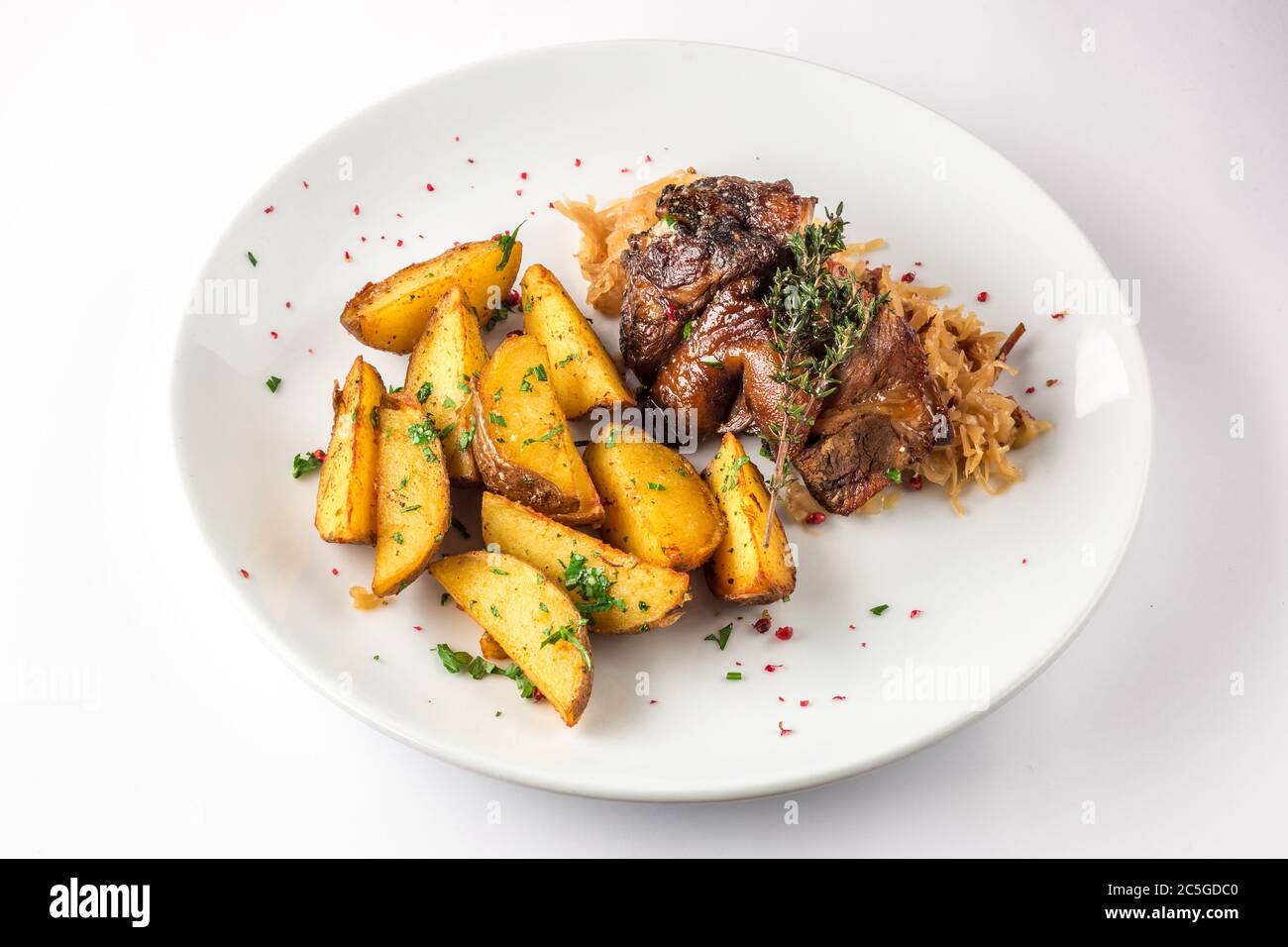 Porte-jarret de porc avec pommes de terre et chou sur une assiette blanche. Mise au point sélective. Banque D'Images