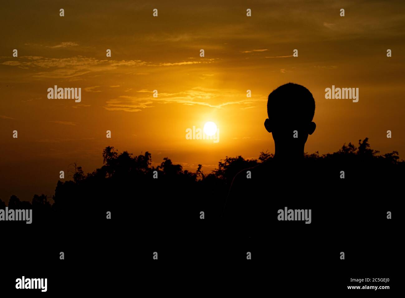 Jeune garçon se tient seul au coucher du soleil.Silhouette de garçon, concept de solitaire, triste, seul et effrayé.Homme se tenir sous le ciel.appréciant le coucher du soleil outdo moment Banque D'Images