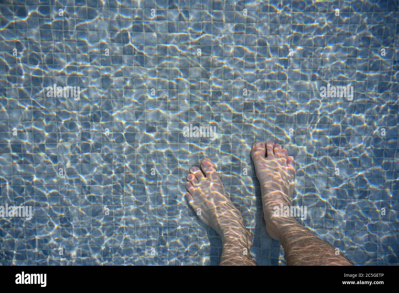 Les pieds dans la piscine le matin reflétant l'eau comme vagues. Mosaïque mélangée à gris foncé et gris clair Banque D'Images