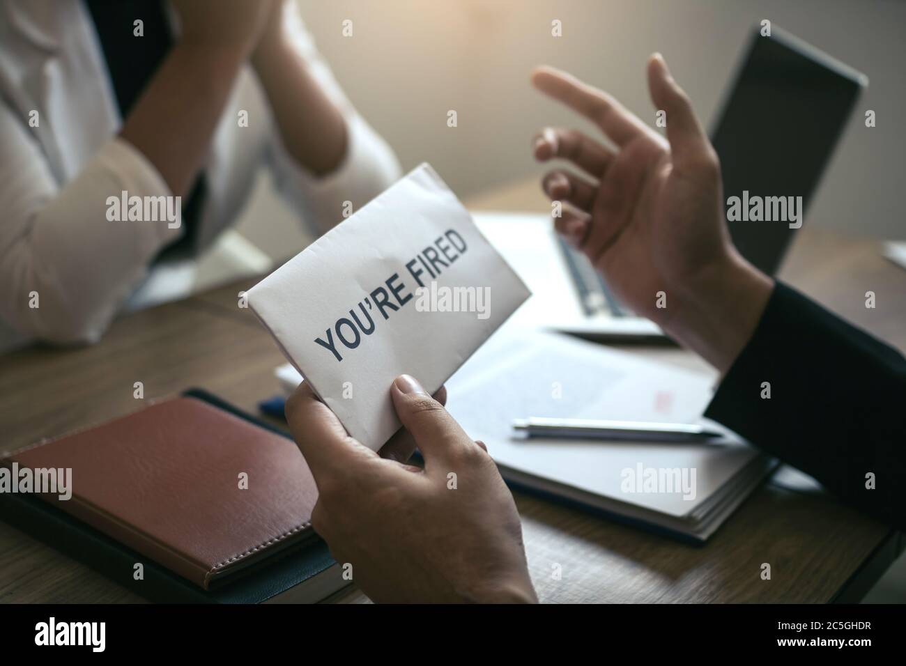 Le Manager masculin parle ou explique qu'il faut licencier l'employé tout en lui donnant une enveloppe de démission. Banque D'Images