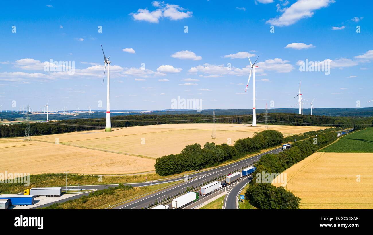 Vue aérienne du moulin à vent contre ciel bleu avec nuages. Parc éolien et route entre les champs agricoles Banque D'Images