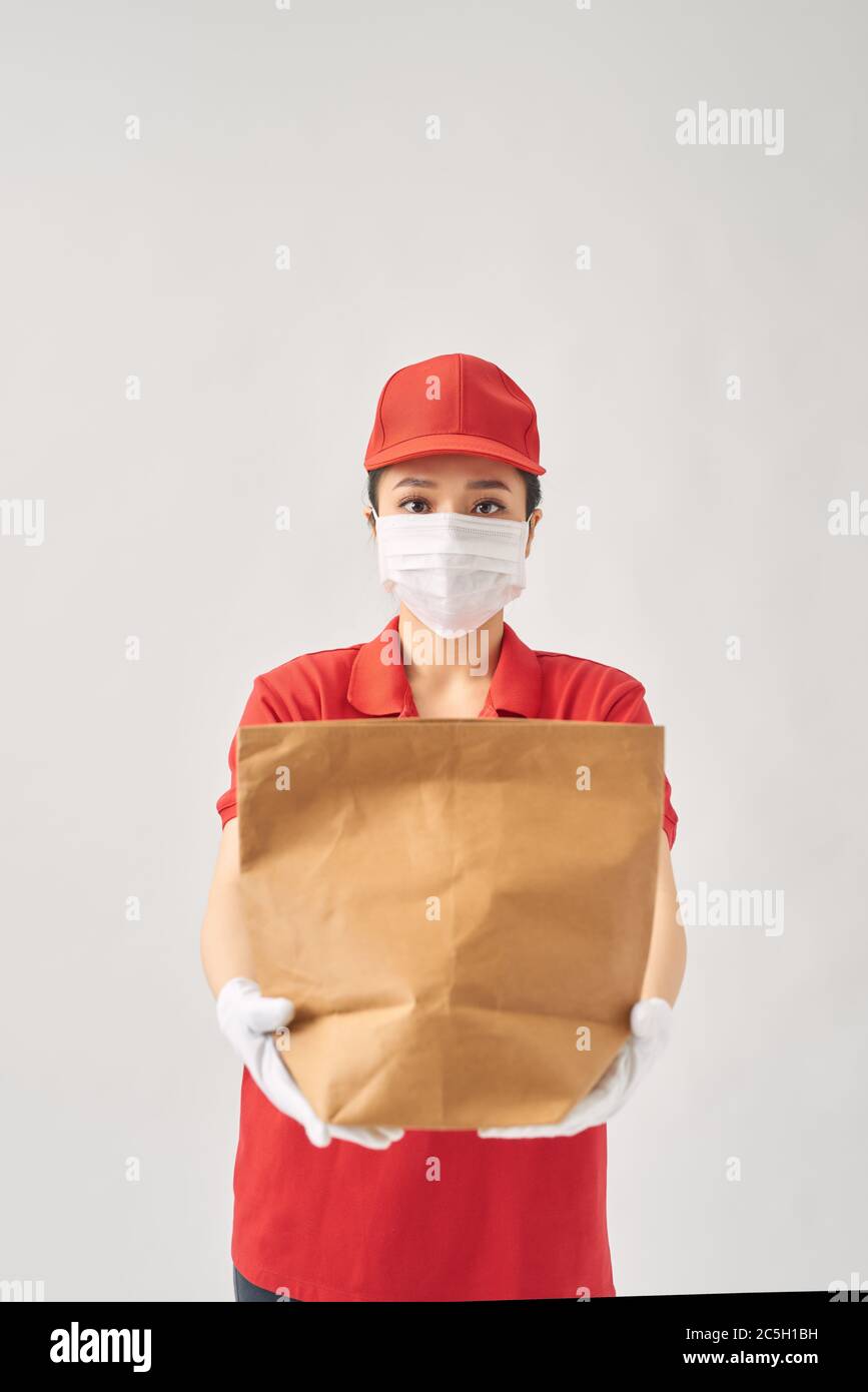 concept de protection de la santé, de sécurité et de pandémie - femme en masque facial protecteur avec nourriture dans un sac en papier sur fond rose Banque D'Images concept de protection de la santé, de sécurité et de pandémie - femme en masque facial protecteur avec nourriture dans un sac en papier sur fond rose Banque D'Images