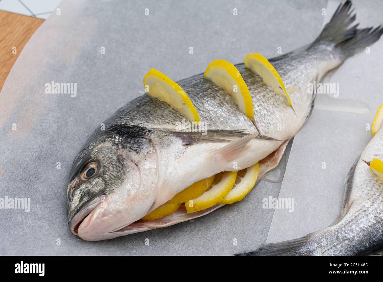 Dorado poisson de mer prêt à cuire. Poisson cru avec citron, huile Banque D'Images