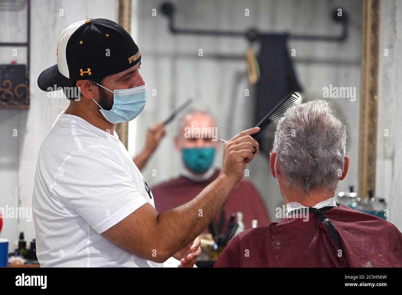 New York, États-Unis. 30 juin 2020. Portant des masques à l'époque de COVID-19, Joe Rivera, propriétaire et exploitant de « The NY Barber », donne à Joe Lewis un cheveu coupé à l'intérieur de son 9ft. Par 24ft. Mobile box Truck salon, New York, NY, 30 juin 2020. M. Rivera a commencé son entreprise de coupe de cheveux mobiles lorsque le bail à son magasin de coiffure a expiré et que le loyer est devenu trop coûteux. (Anthony Behar/Sipa USA) crédit: SIPA USA/Alay Live News Banque D'Images