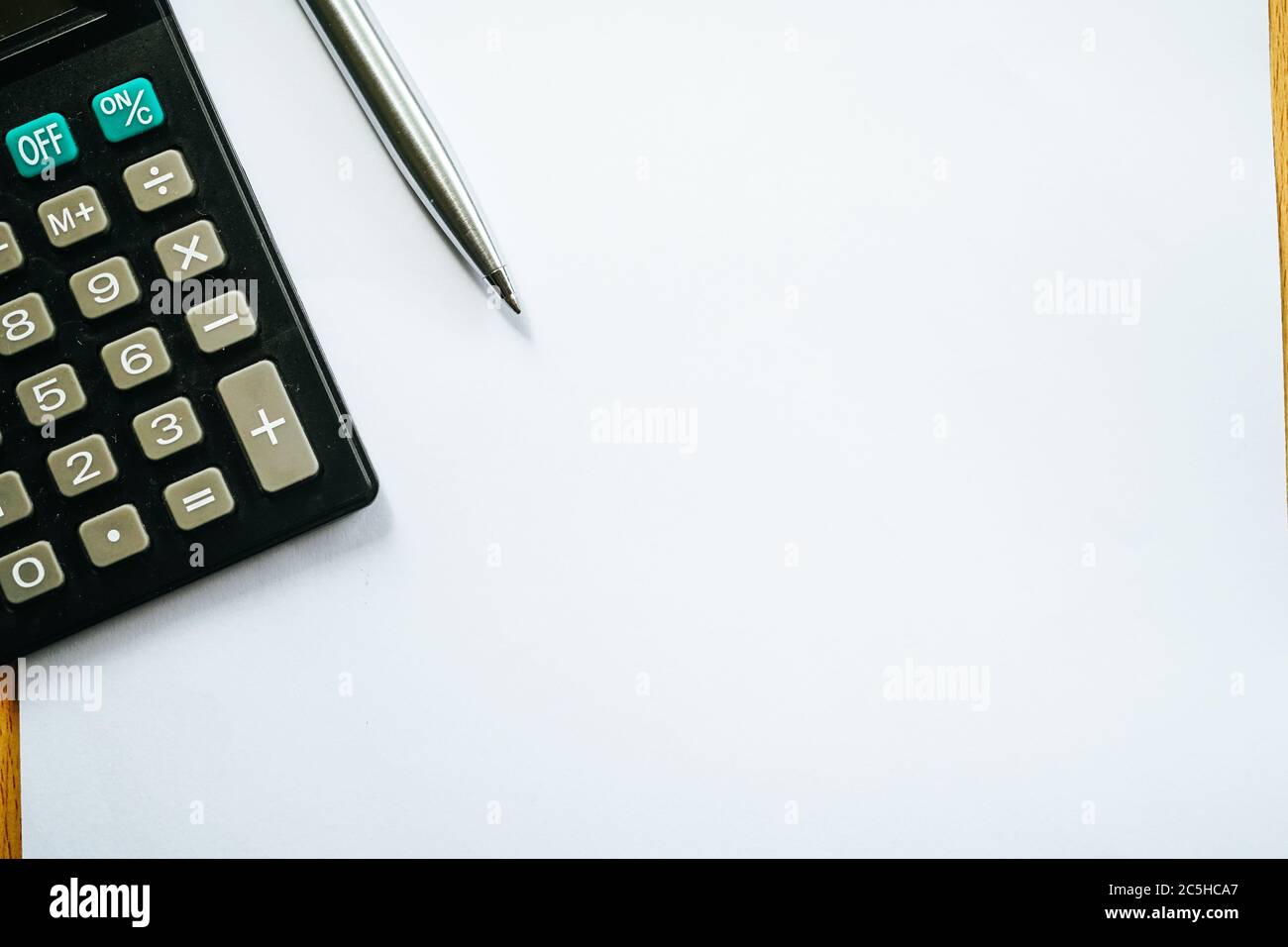 Poser le stylet et la calculatrice sur un fond de papier blanc. Prenez note et concept financier. Banque D'Images