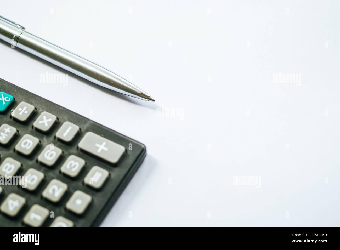 Poser le stylet et la calculatrice sur un fond de papier blanc. Prenez note et concept financier. Banque D'Images