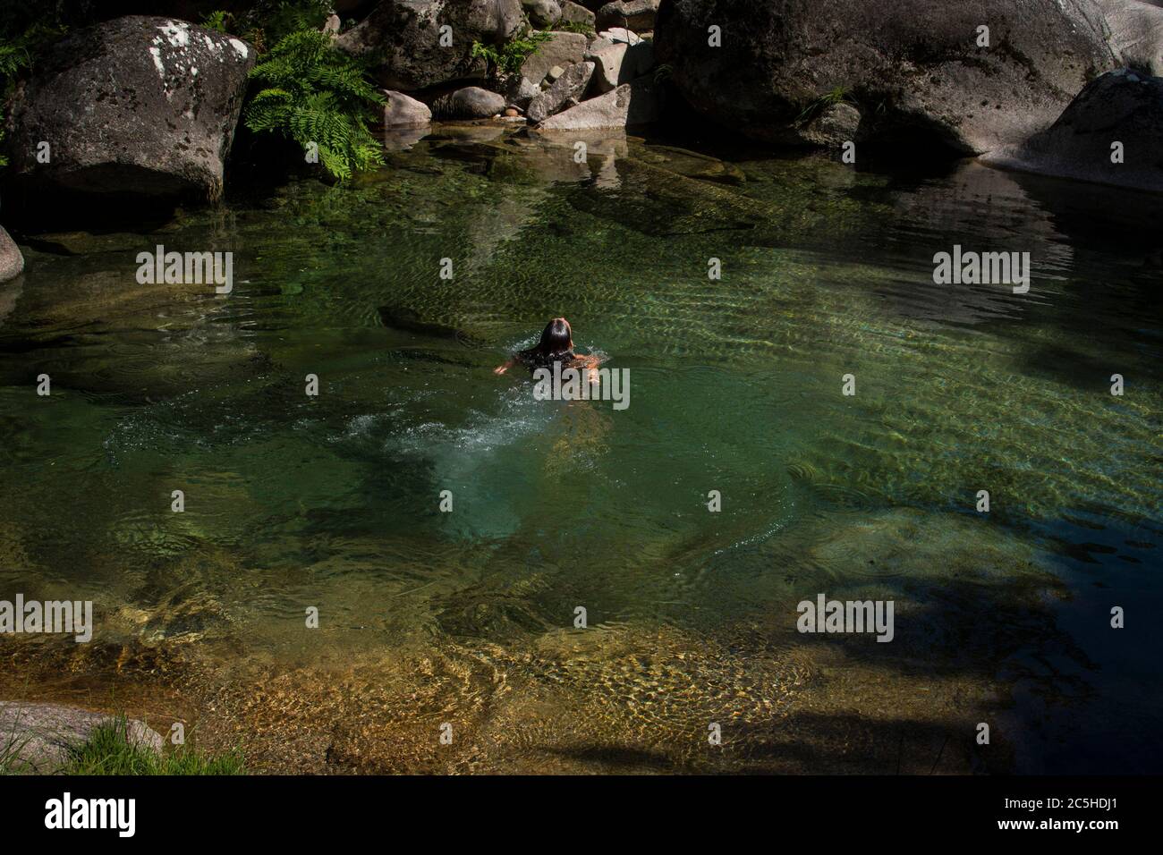 Femme plongée dans l'eau claire verte dans un lac de montagne, isolé dans la nature Banque D'Images