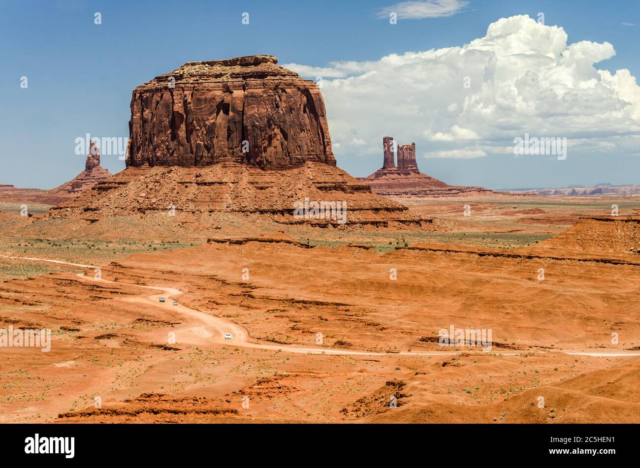 Photo aérienne de la route de terre avec de petites voitures dans un paysage magnifique du désert avec d'énormes mécas rouges en arrière-plan Banque D'Images