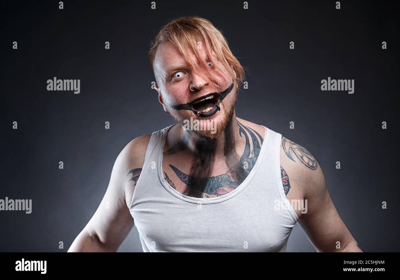 Tatoué homme fou effrayant avec maquillage d'horreur Banque D'Images