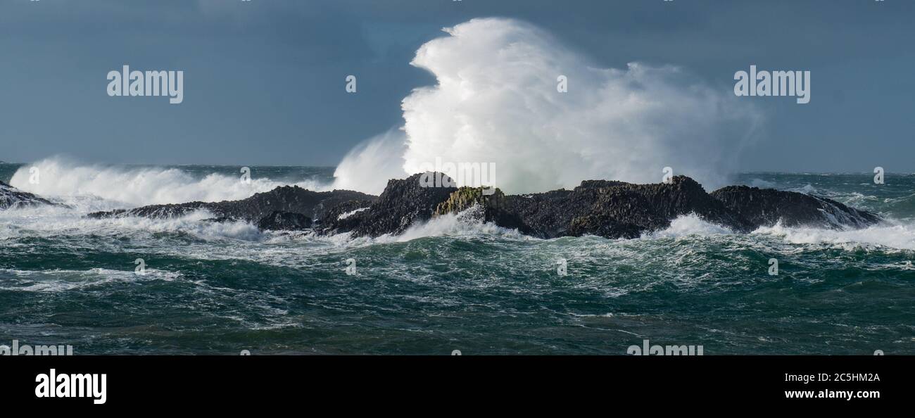 Des vagues massives se sont écraées sur les rochers du port de Ballintoy, sur la côte de Causeway, en Irlande du Nord Banque D'Images