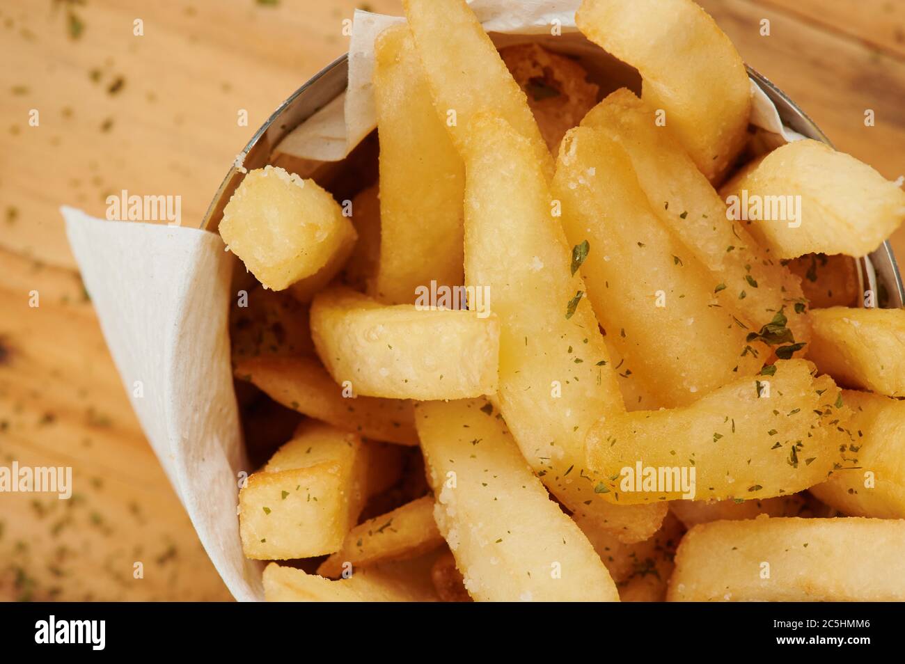 Frites croustillantes dans une tasse sur une table en bois vue rapprochée Banque D'Images