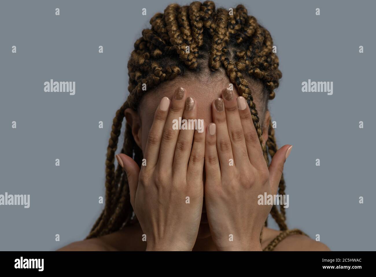Jeune Afro-américaine qui ferme son visage avec deux paumes Banque D'Images