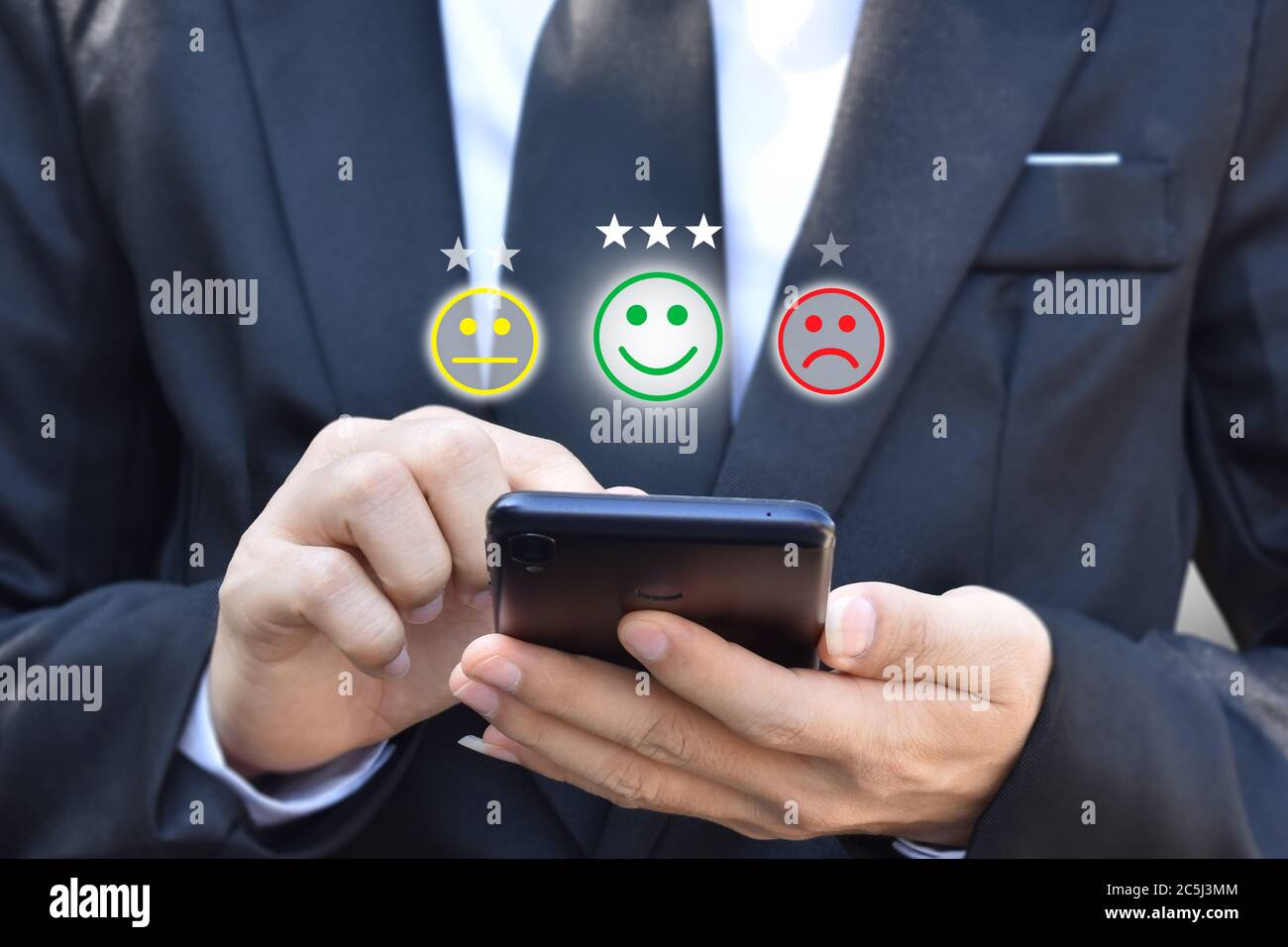 Homme d'affaires appuyant sur émoticône visage dans smartphone à l'affichage sur l'écran virtuel. Concept d'évaluation de la satisfaction du service client et de rétroaction. Banque D'Images